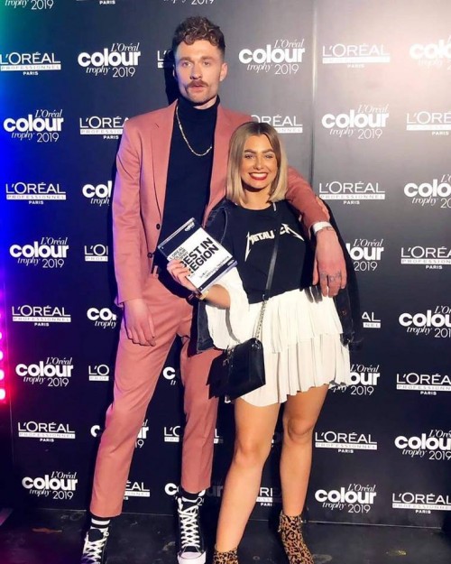 Our senior stylist Ashley Wallce standing alongside her winning Men's Image style on her model at the L'Oreal Colour Trophy 2019.